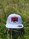 White cap with a red and black logo on grass